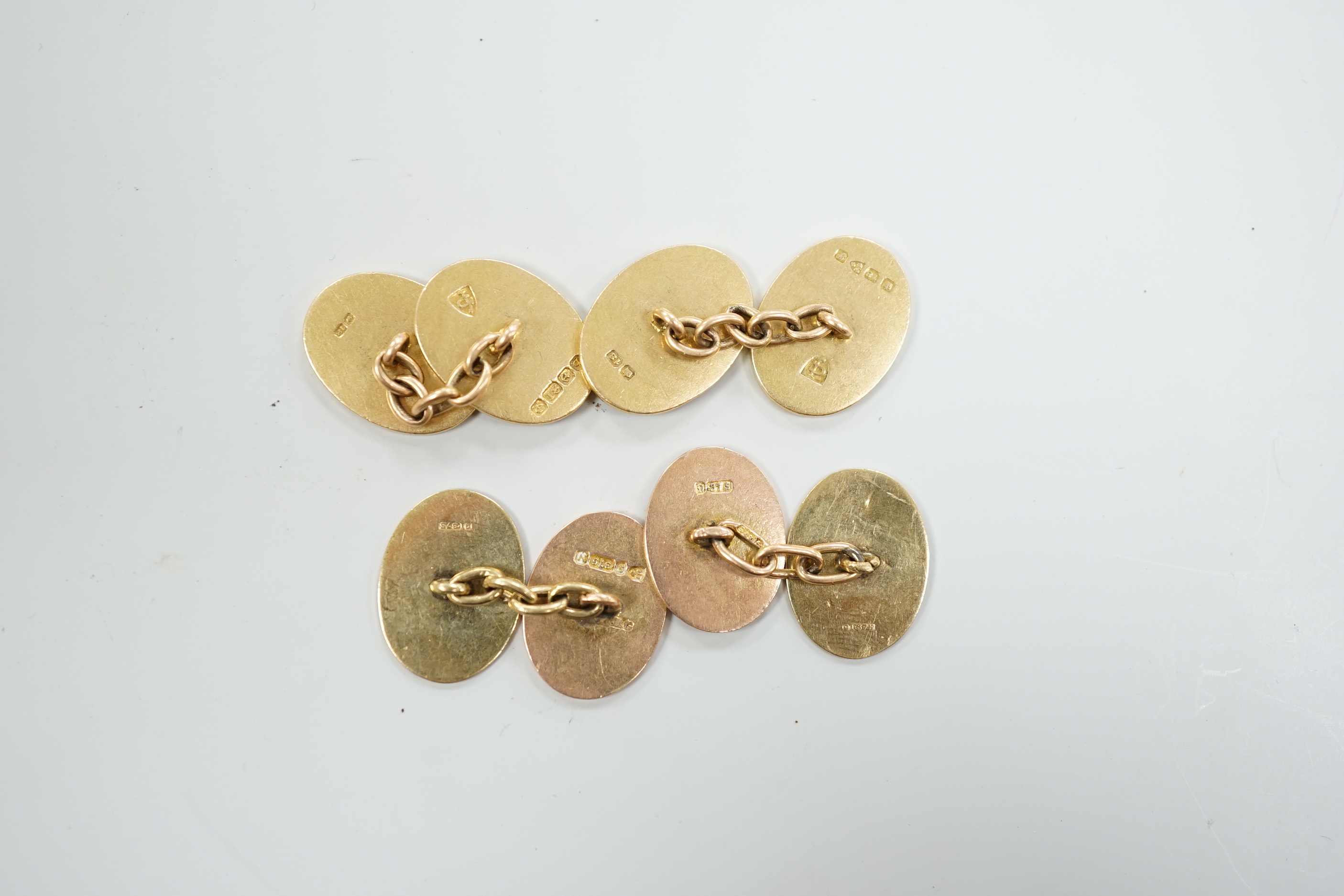 A pair of George V 18ct gold oval cufflinks, with engraved crest and initials, G.H. Johnstone & Co, Birmingham, 1915, 16.7 grams and a pair of late Victorian engraved 9ct gold oval cufflinks, 6.7 grams.